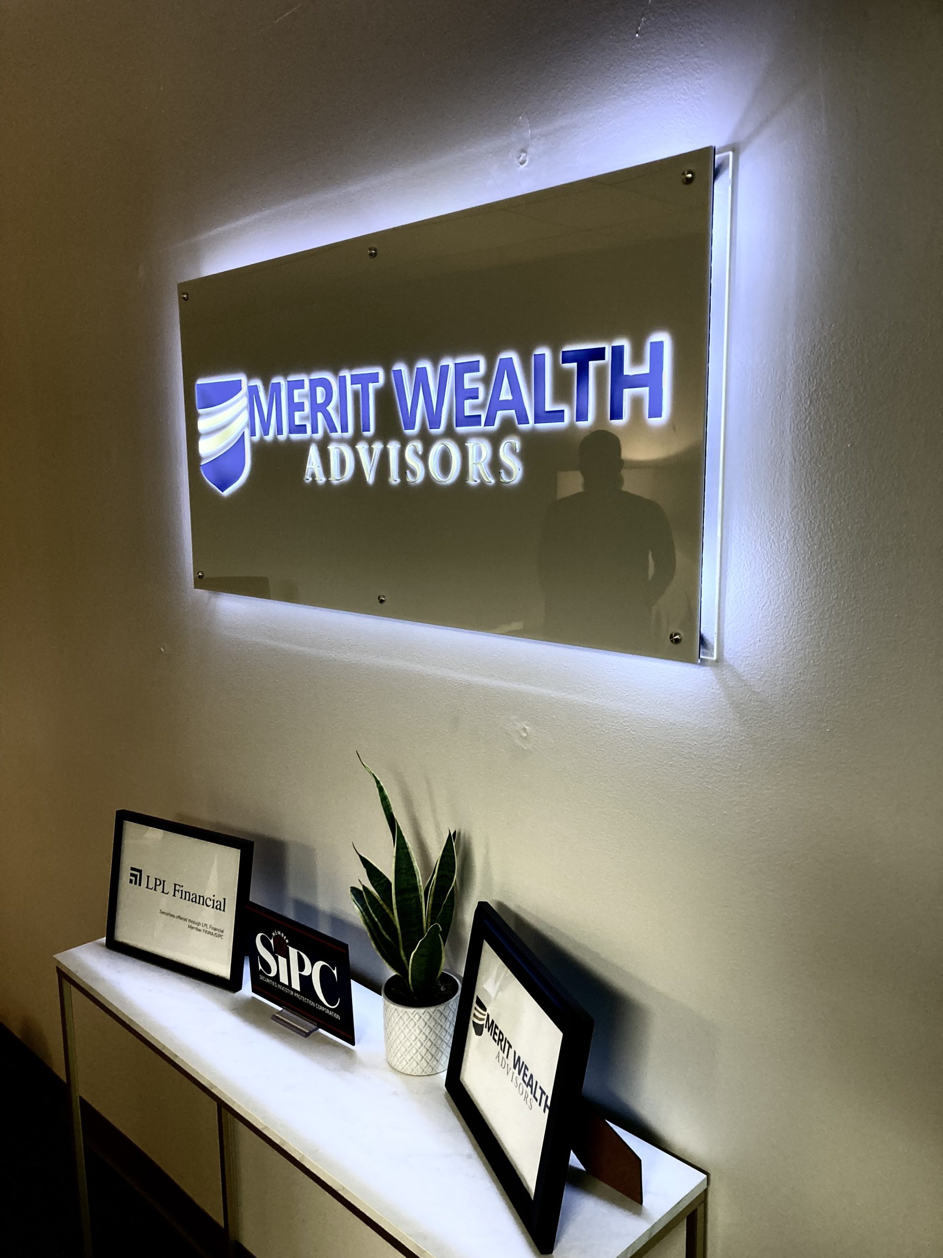 lighted lobby sign of Merit Wealth business in Orlando, FL
